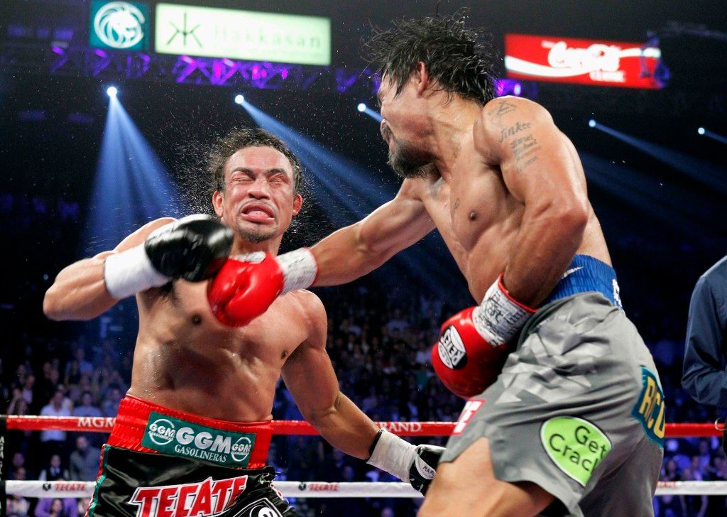 Juan Manuel Marquez of Mexico takes a punch from Manny Pacquiao of the Philippines during their welterweight fight at the MGM Grand Garden Arena in Las Vegas